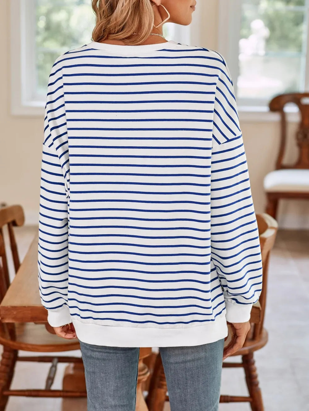 Back view of white sweatshirt with blue horizontal stripes, round neck long sleeves