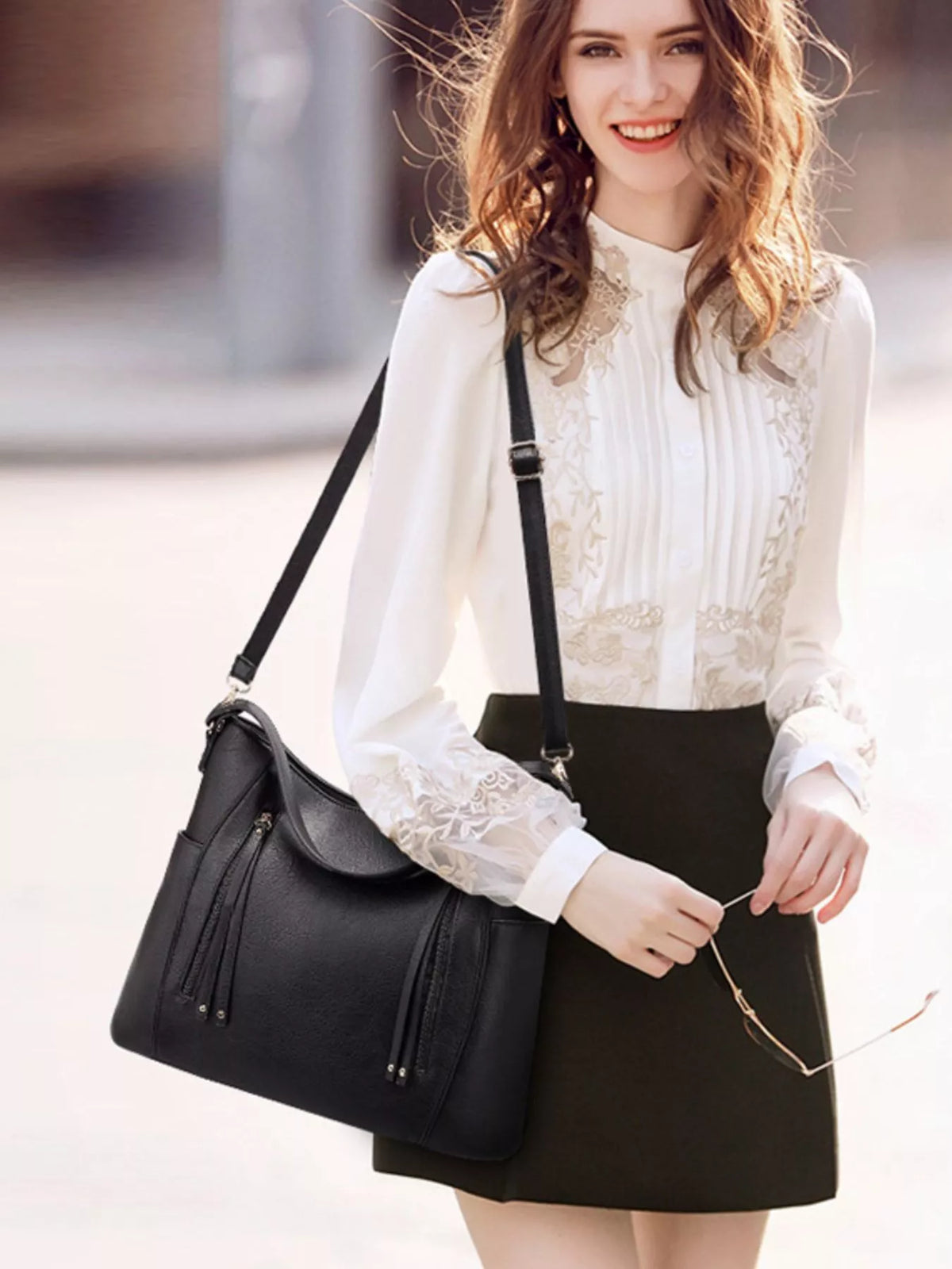 Vegan leather shoulder bag with long strap and front zip tassel details