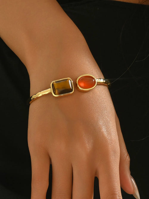 Gold tone geometric open bracelet with orange oval and dark square insets