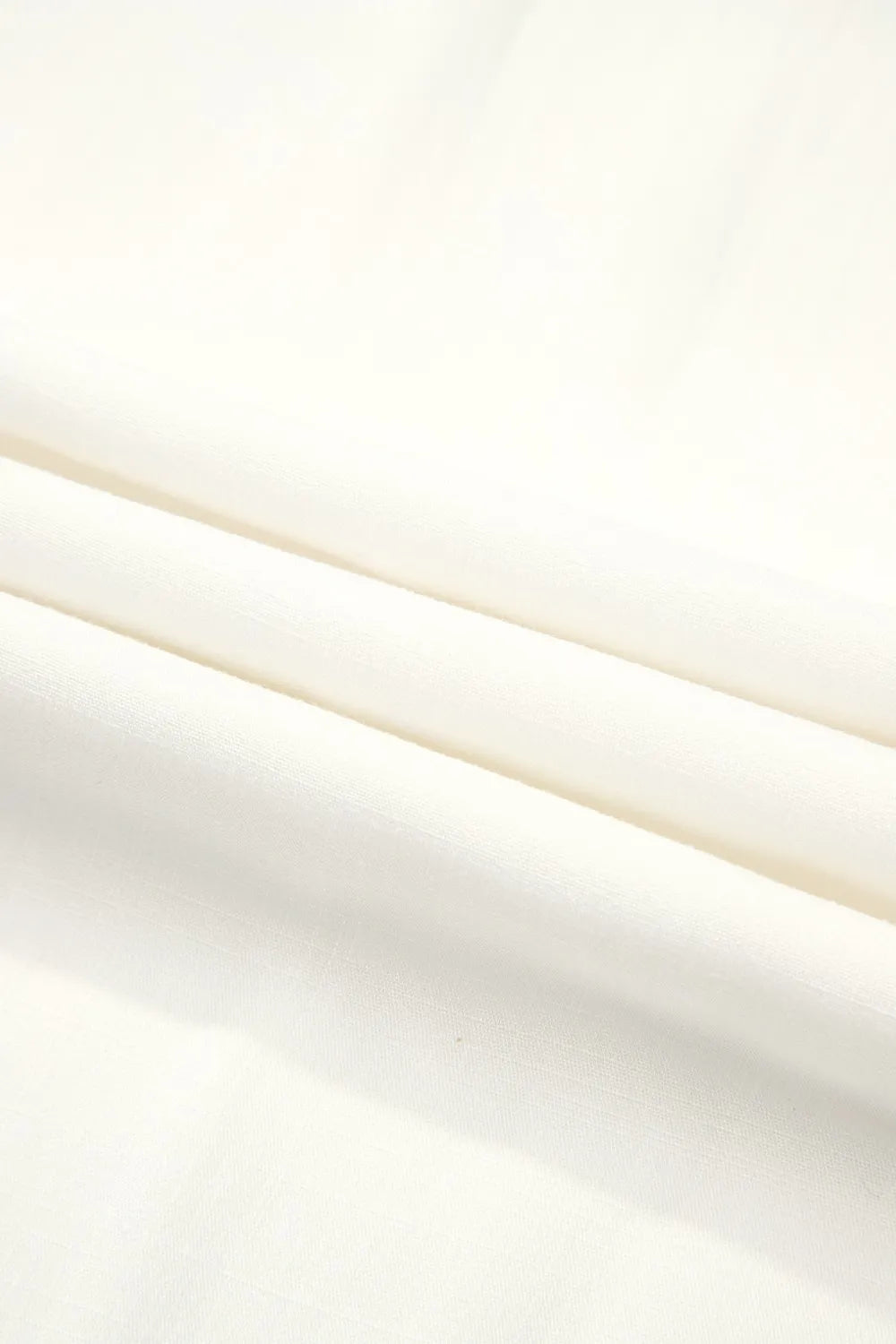 White woven fabric with soft gathers on wide-leg pants