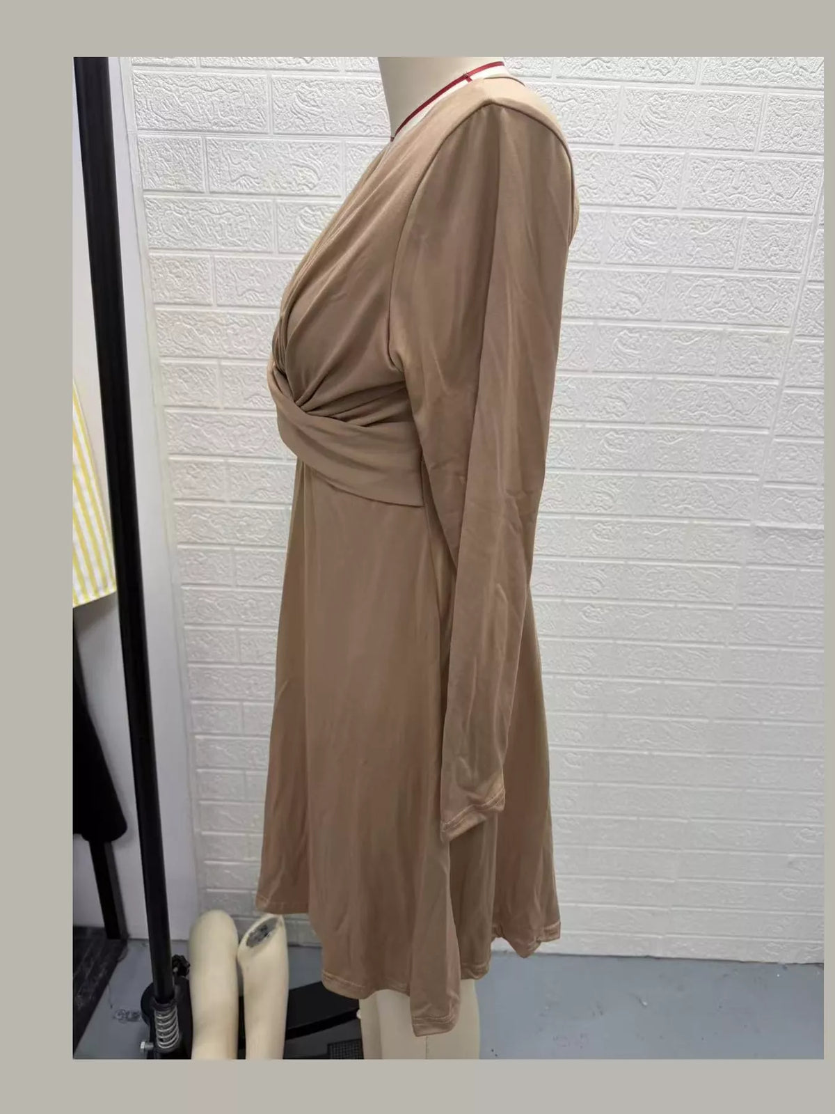 Beige ruched midi dress side view with V-neck, long sleeves, and gathered waist.