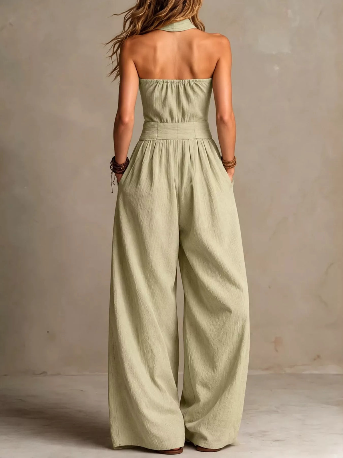 Back view of high waist halter linen jumpsuit with open back and wide-leg pants in sage