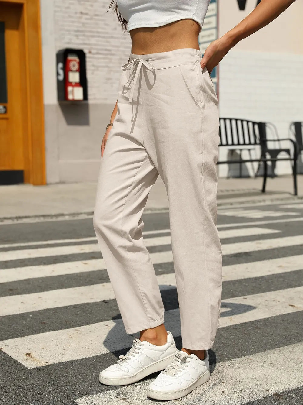 White elastic waist tapered pants with drawstring ties, slanted front pockets