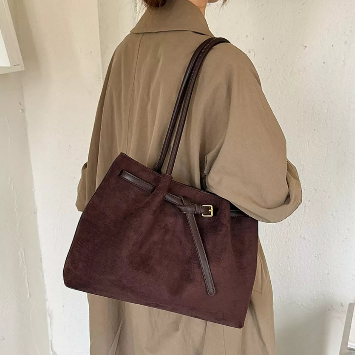 Dark brown suede shoulder bag with structured shape, front pocket, and shoulder strap