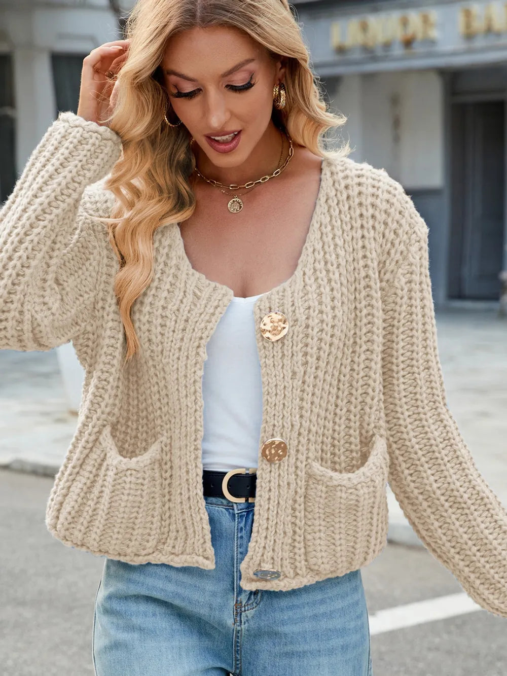 Cream round-neck button cardigan with front patch pockets and long sleeves