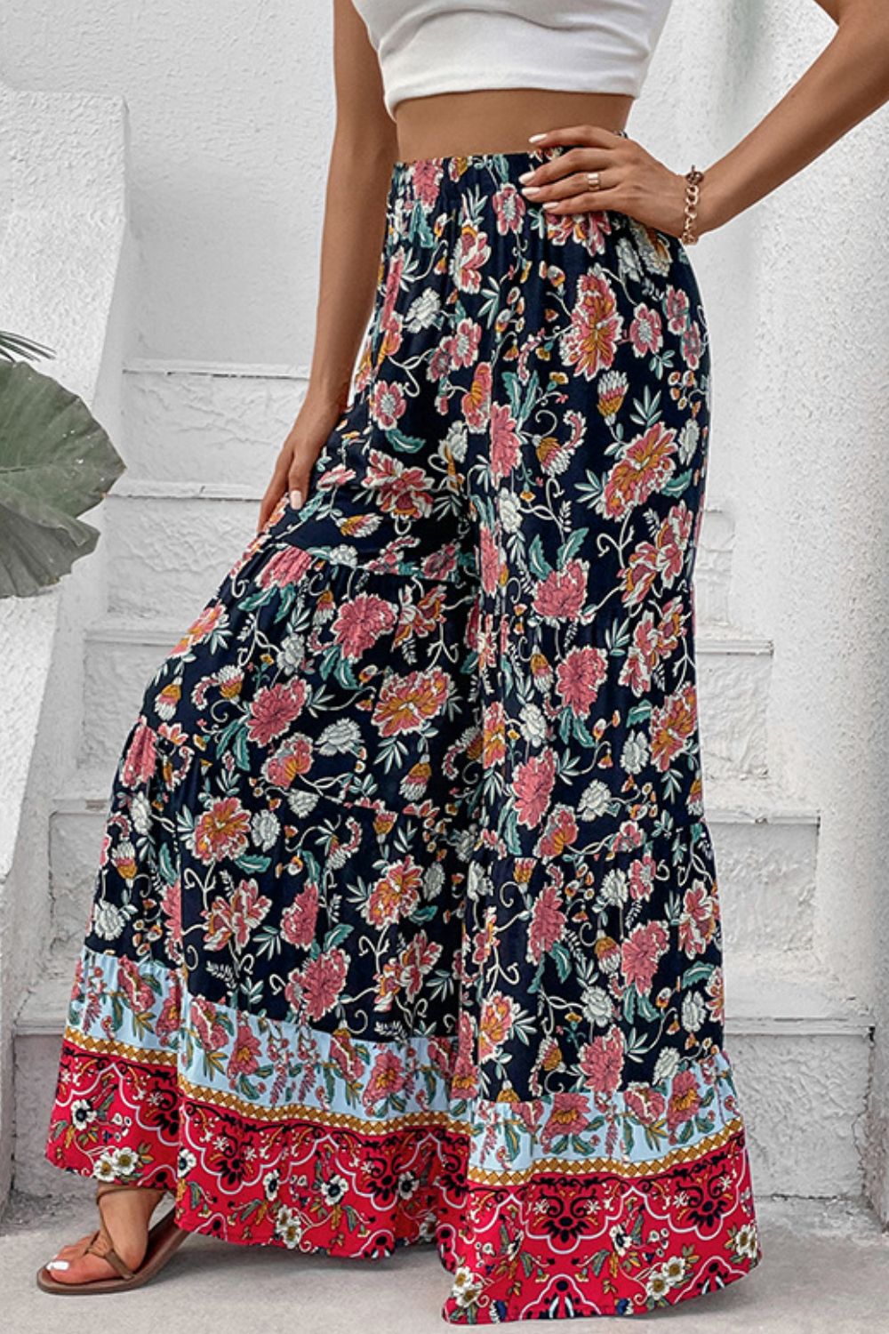 Floral high-waist palazzo pants with gathered waist, pink blooms, and red patterned hem border