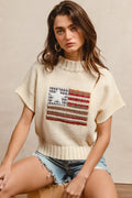 Oatmeal knit drop-shoulder sweater with short sleeves and American flag patch on chest