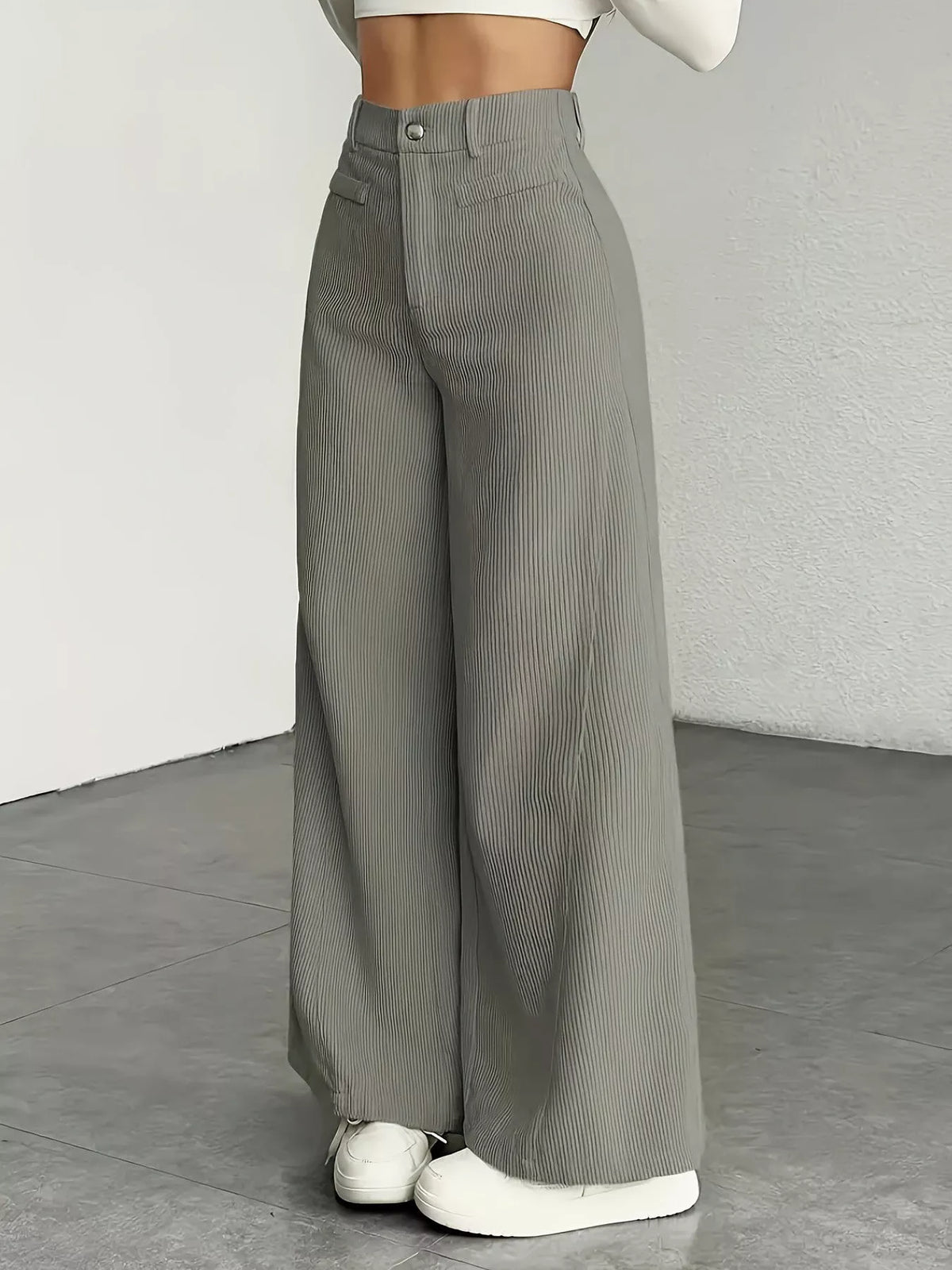High-waisted wide-leg pants in dark gray, front pockets, button-and-zip closure.