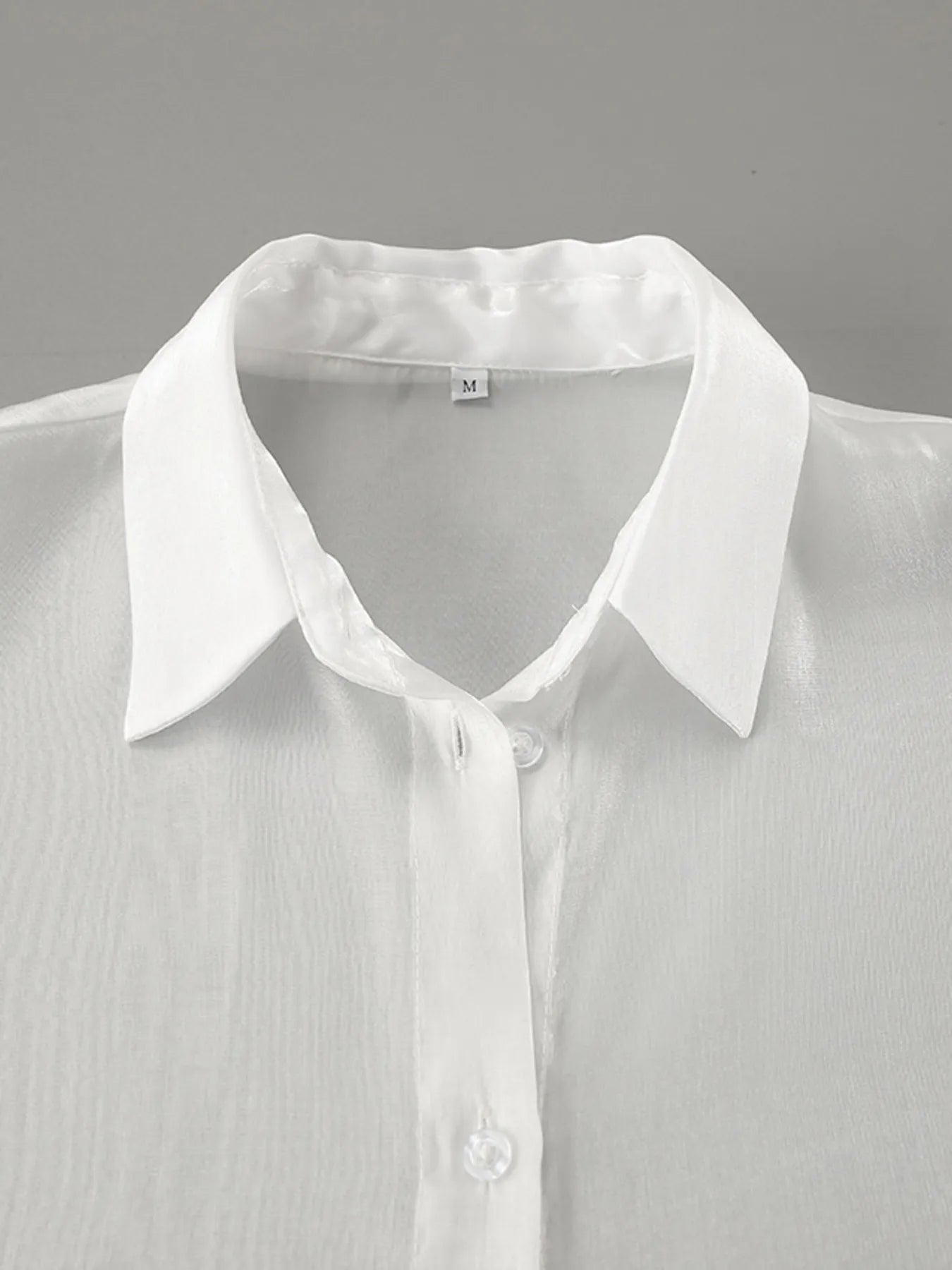 White button-up flounce sleeve shirt close-up of collar and button placket