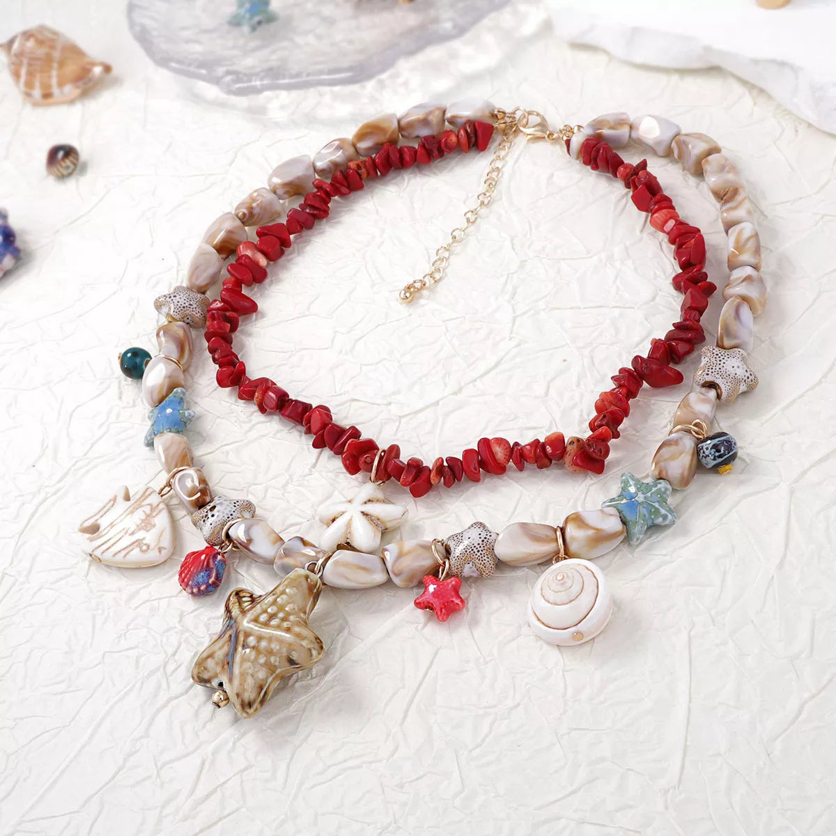 Beaded multi-strand shell charm necklace with starfish, flower, and spiral shell charms