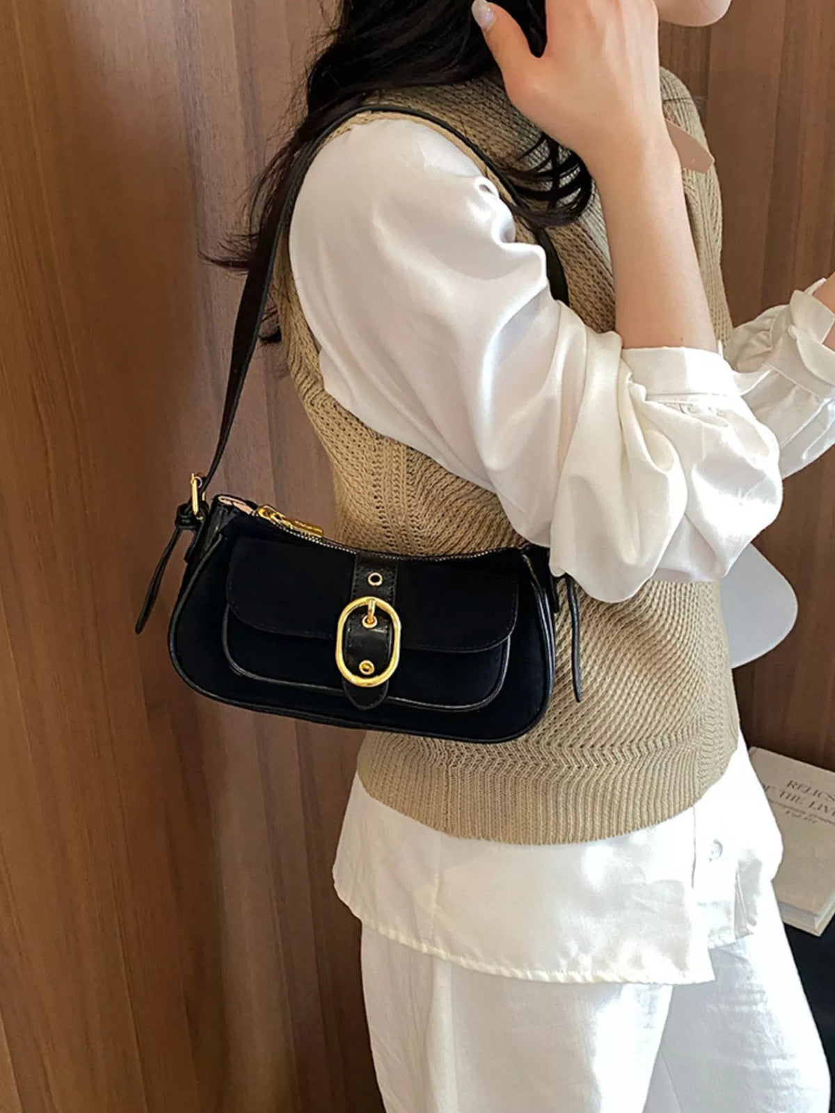 Black suede shoulder bag with front buckle, gold-tone hardware, and crossbody strap