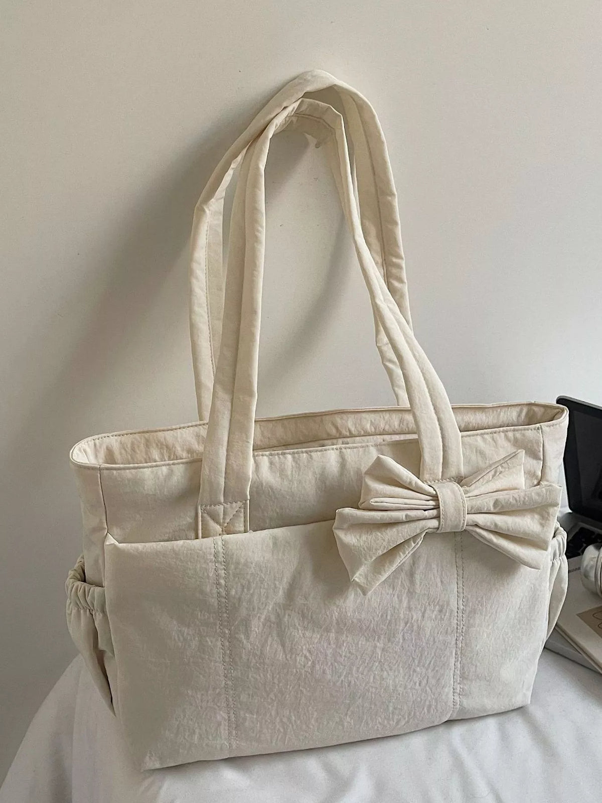 Ivory medium casual tote bag with front bow accent and quilted side panels