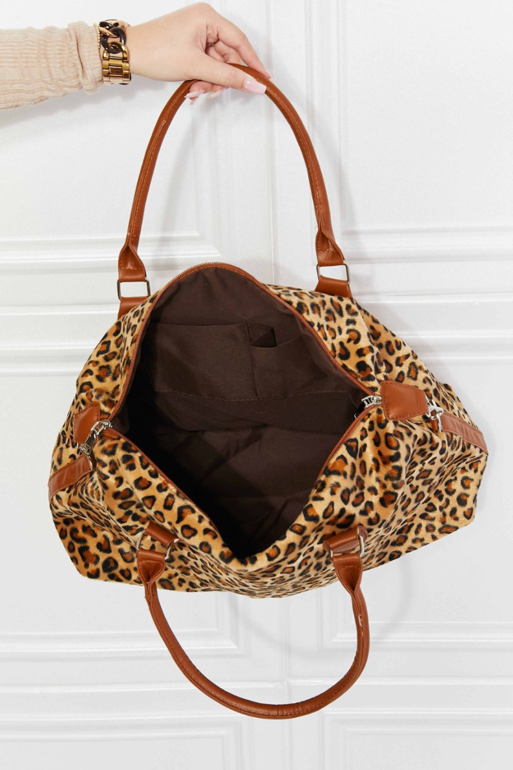 Leopard print weekender bag open view with tan handles and brown interior lining