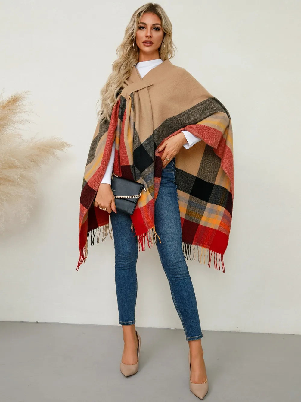 Plaid contrast fringe poncho in tan base with red, yellow, and black check blocks