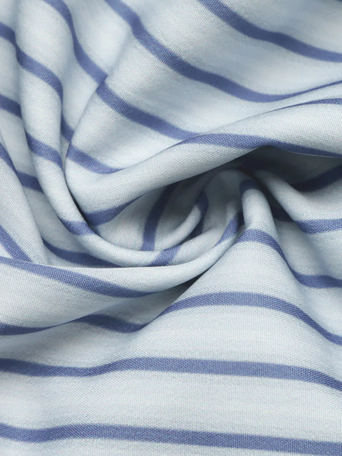 Blue and white striped fabric closeup with soft gathered folds