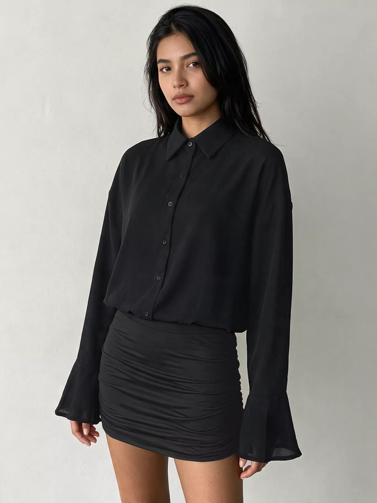 Black button-front mini dress with ruched bodycon skirt and flared sleeve openings
