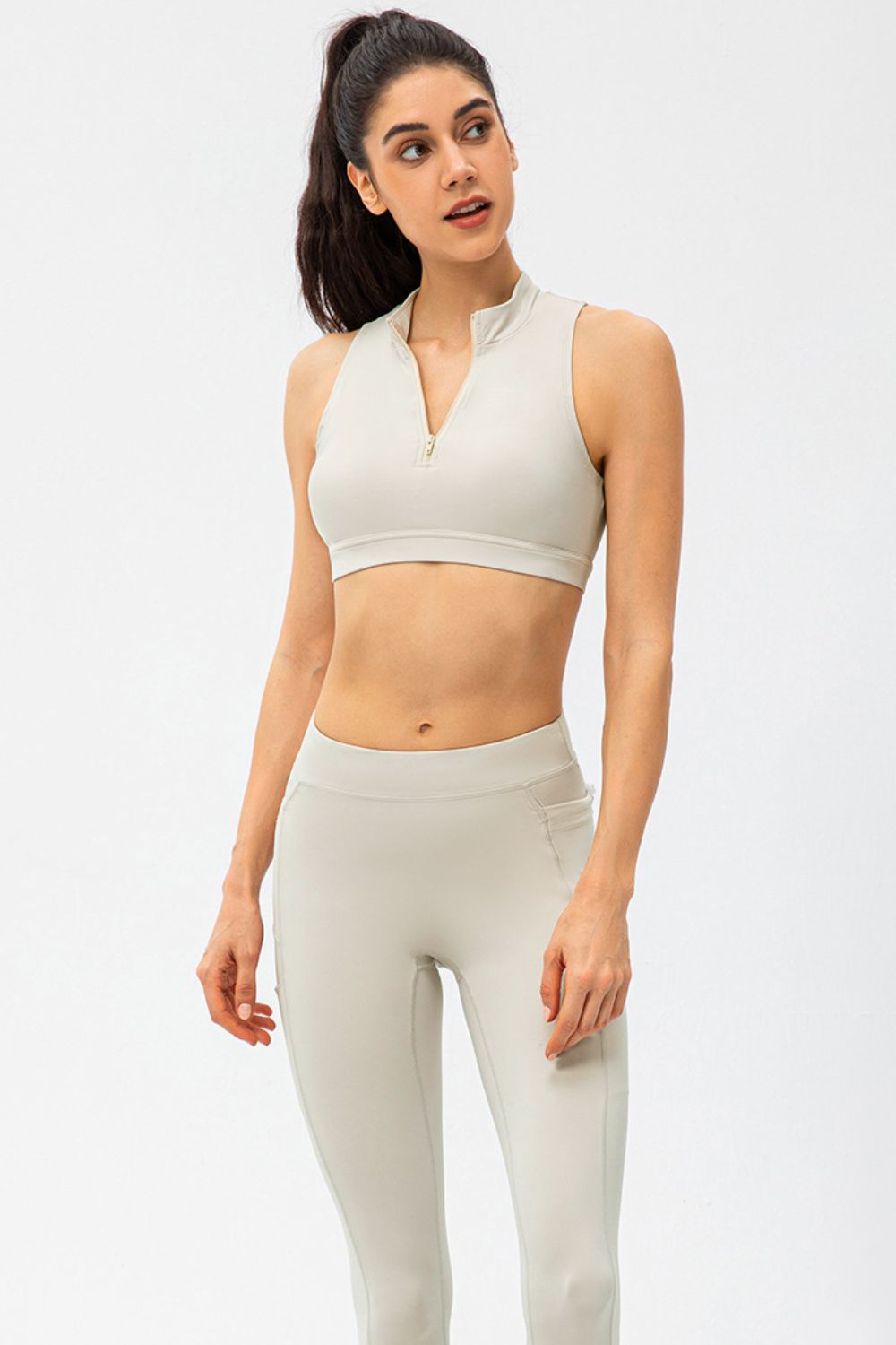 White cropped active tank top with sleeveless design and front half-zip closure
