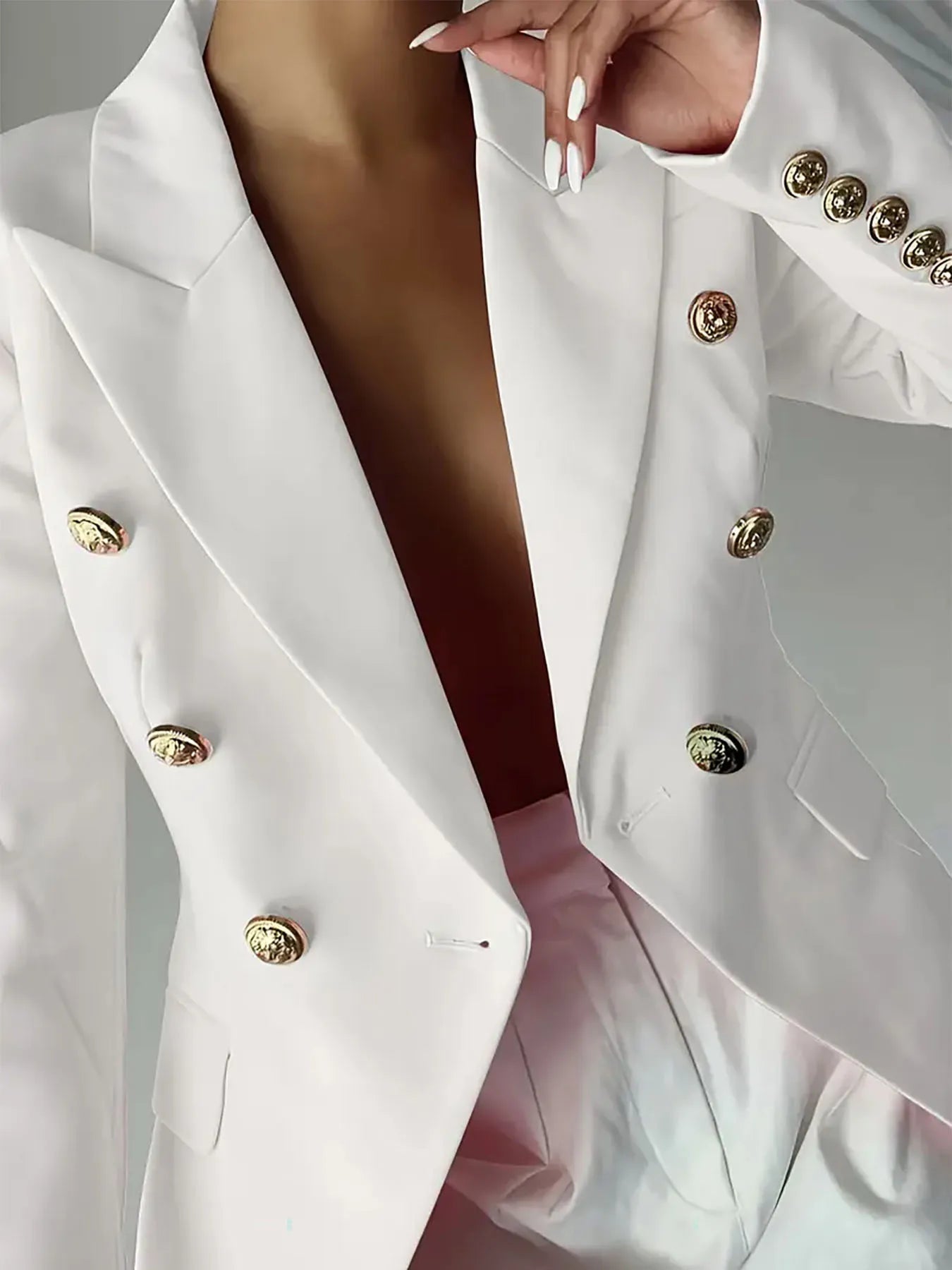 White double-breasted blazer with gold buttons, deep V lapels, and structured cuffs