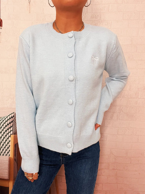 Light blue knit cardigan with round neck, long sleeves, and visible button placket