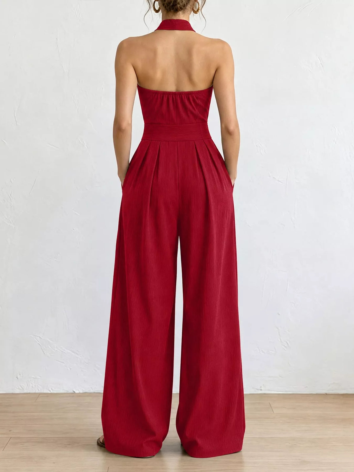 Back view of red halter linen jumpsuit with open back and wide legs
