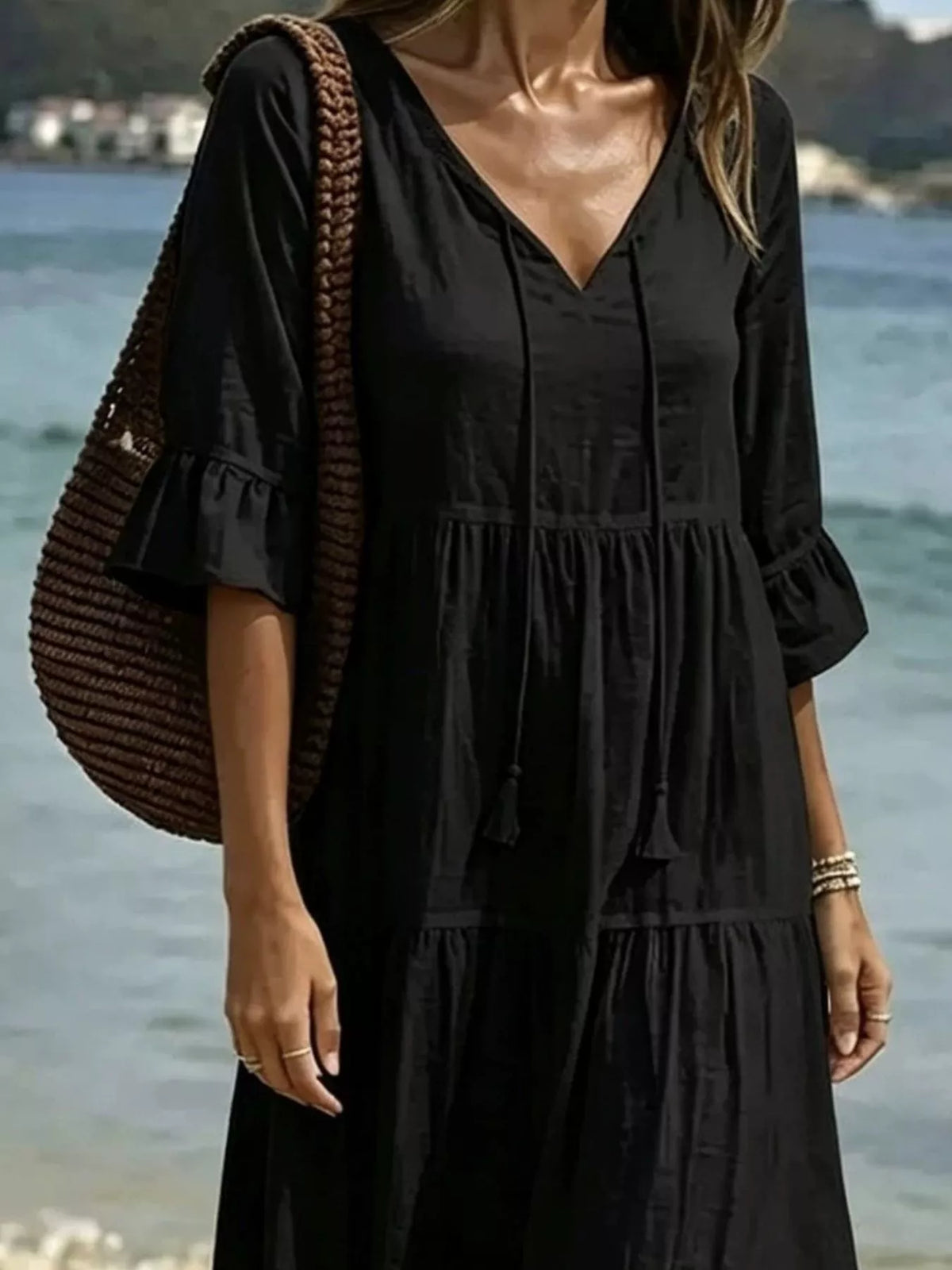 Black tiered tie-neck flounce sleeve dress with V neckline and tassel ties