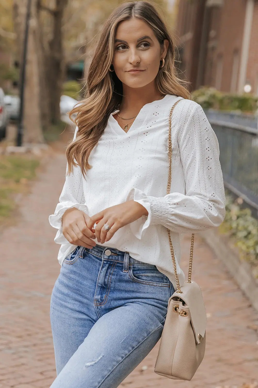 White openwork notched blouse with flounce sleeves, front view, long puff cuffs