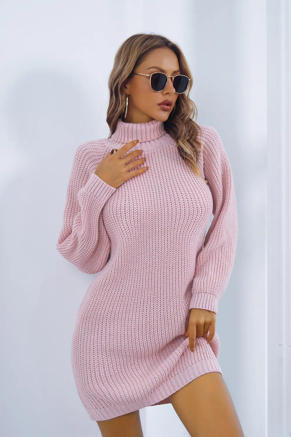 Pink knit turtleneck sweater dress with long sleeves, side buttons and fitted hem