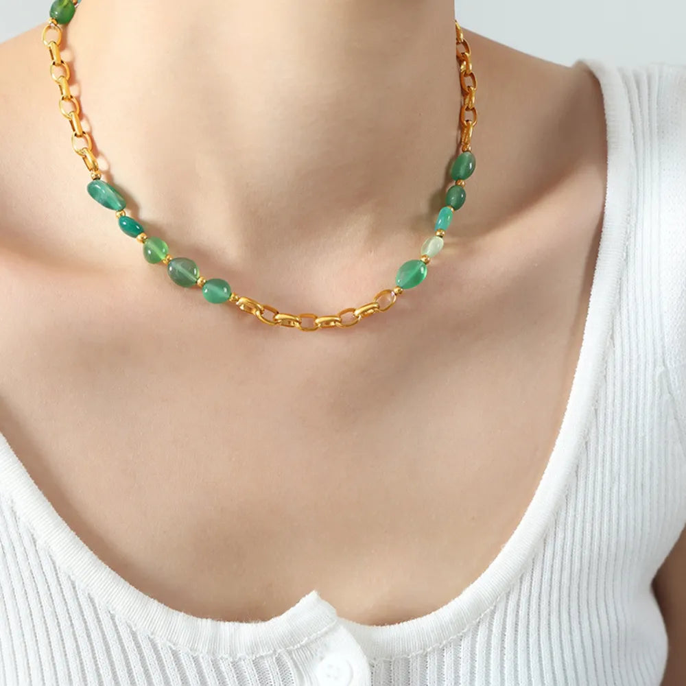 Gold beaded necklace with green oval beads and a small gold link chain center