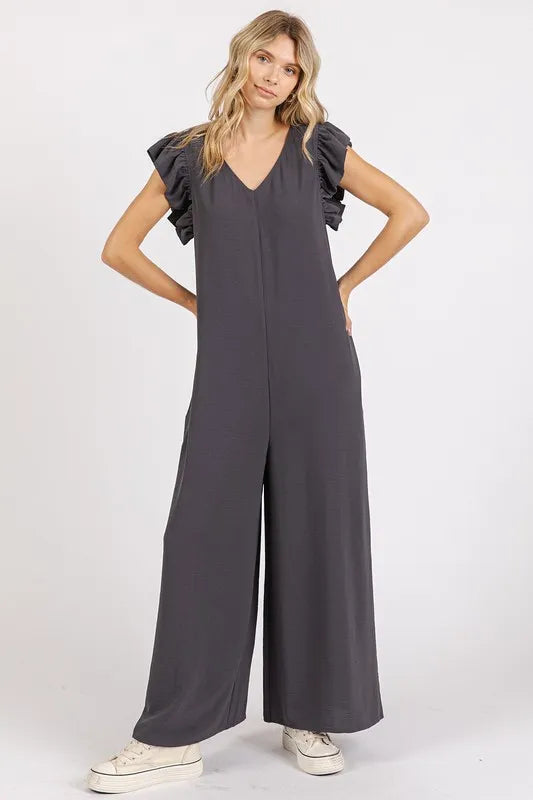 Charcoal v-neck ruffled cap sleeve wide-leg jumpsuit, hands-on-hips