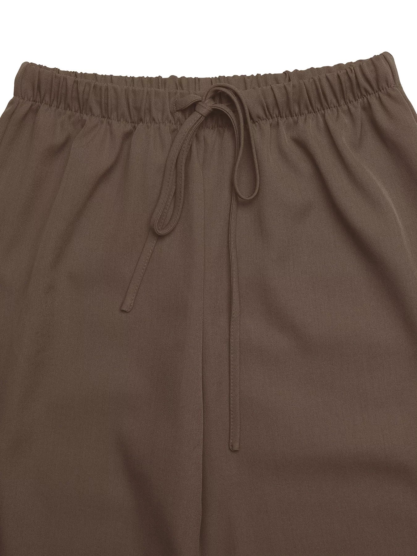 Brown elastic waistband drawstring detail on wide-leg pants.
