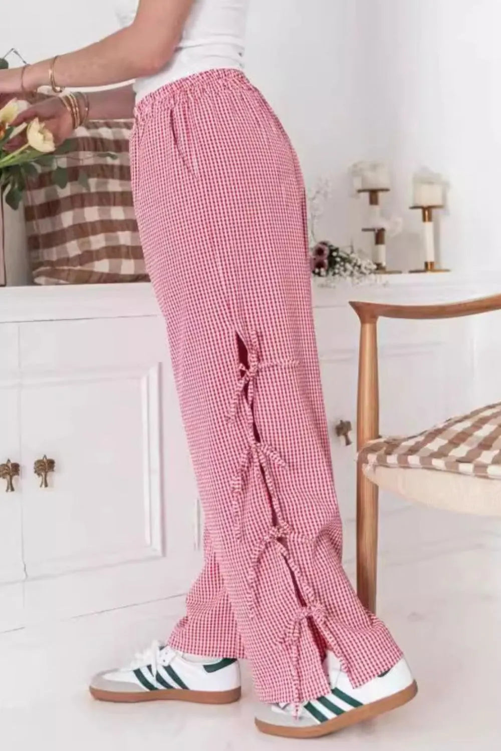 Pink gingham wide-leg pants with front tie bow and tassel-trim sides