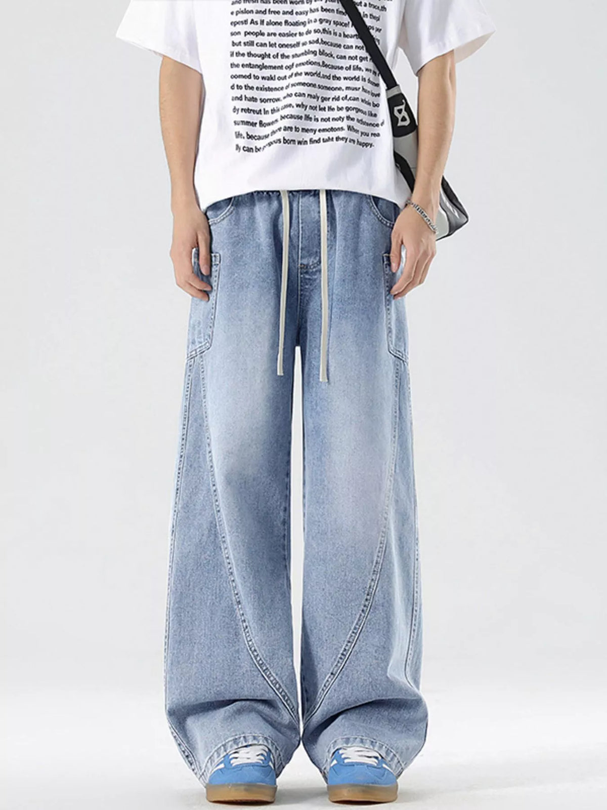 Men's vintage wide-leg jeans in light blue denim with drawstring waist and wide legs.