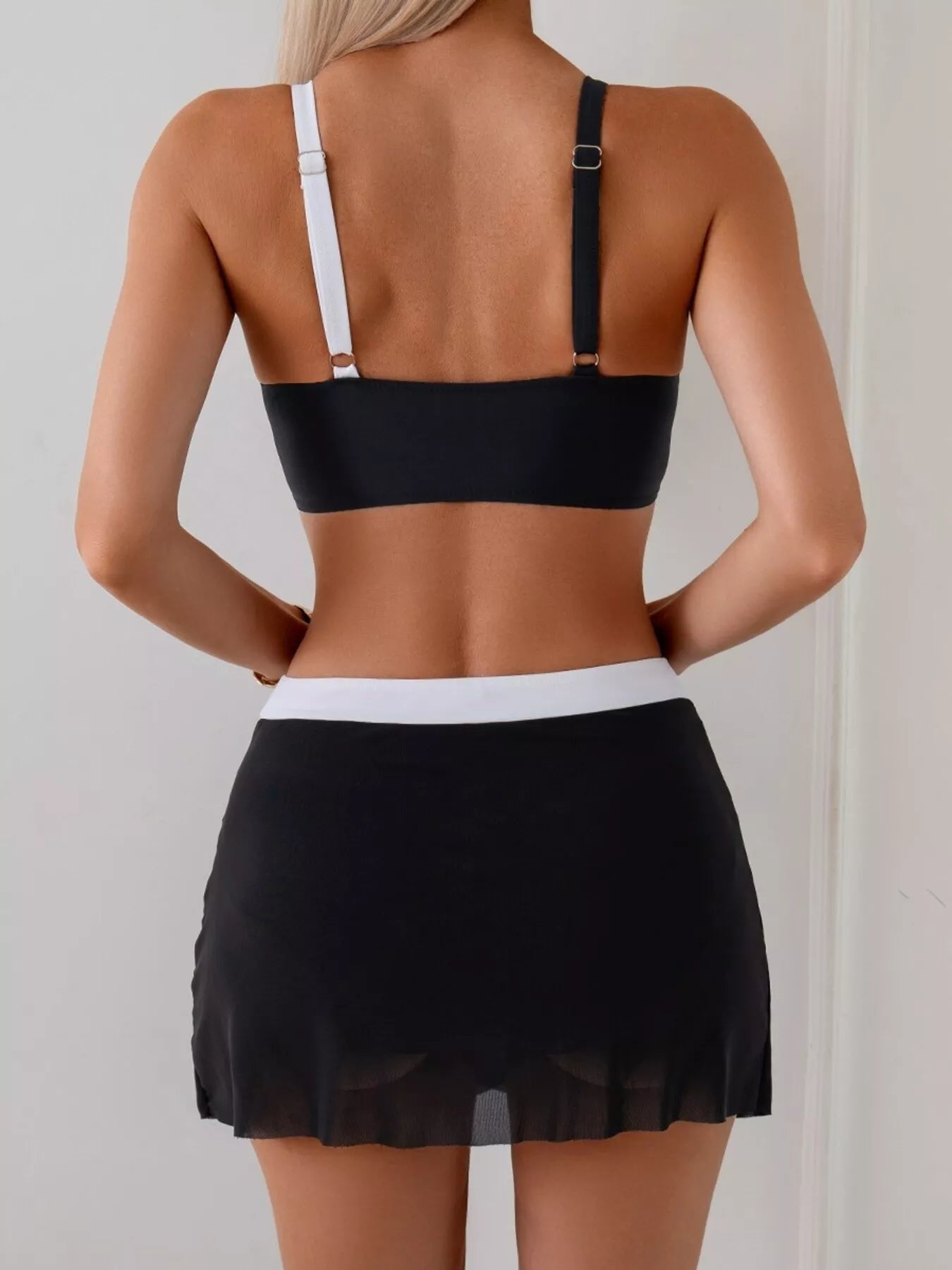 Two Tone Cami and Skort Swim Set by Trendsi; back view with black top, white strap, and black skirt with white waistband
