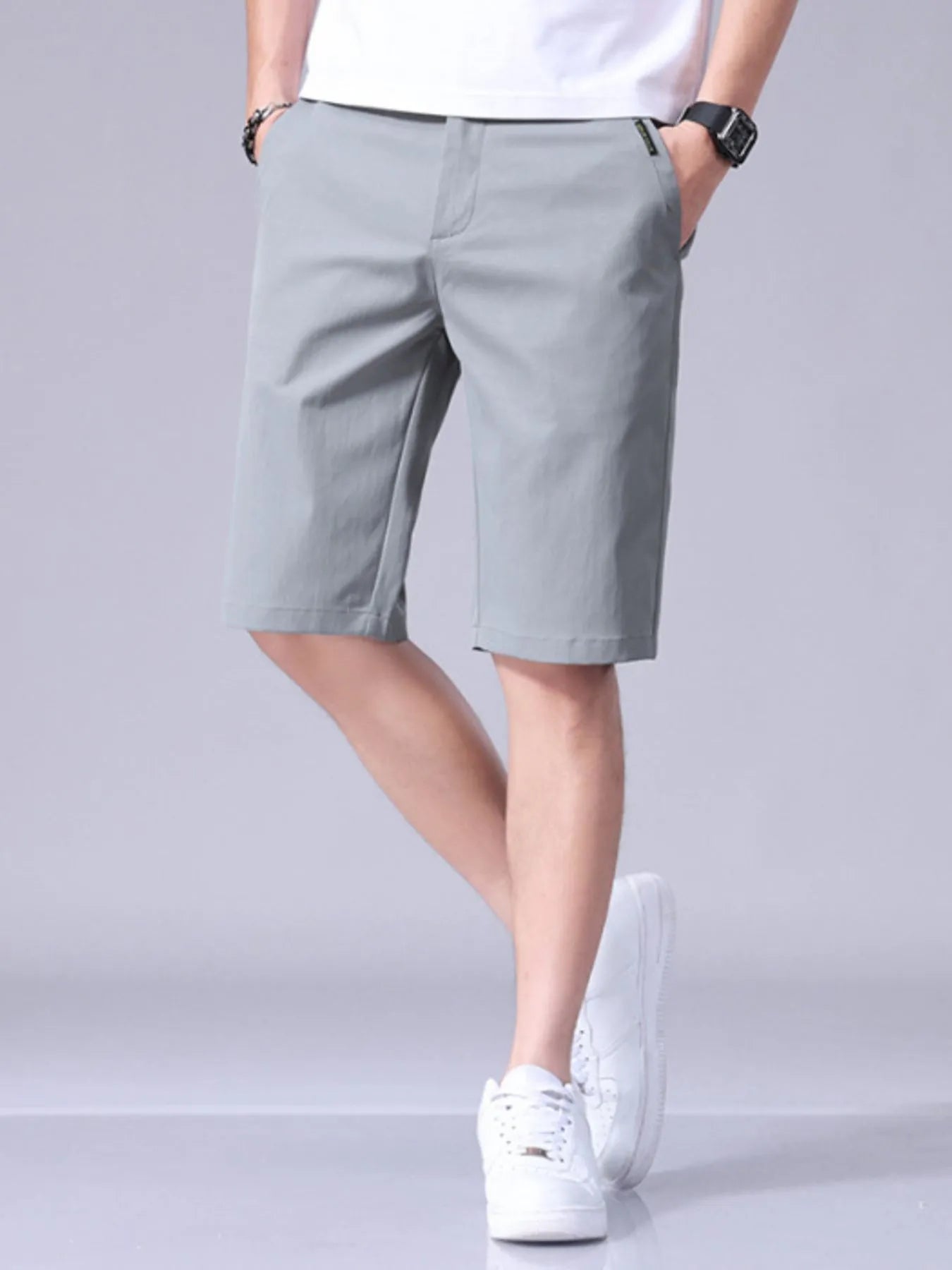 Light gray men's casual shorts with pockets and belt loops, knee-length