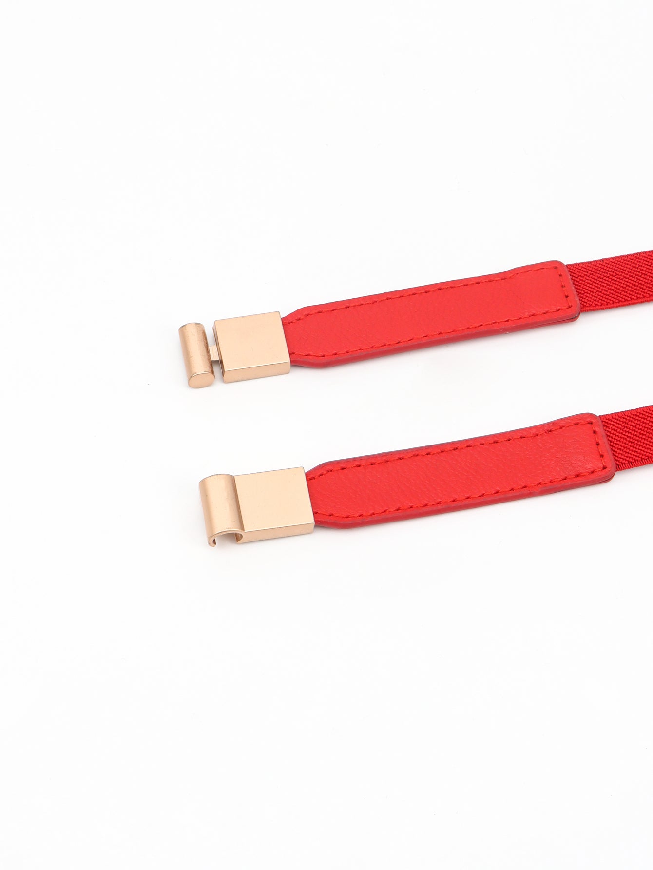 Red elastic skinny belt with gold-tone buckle, close-up