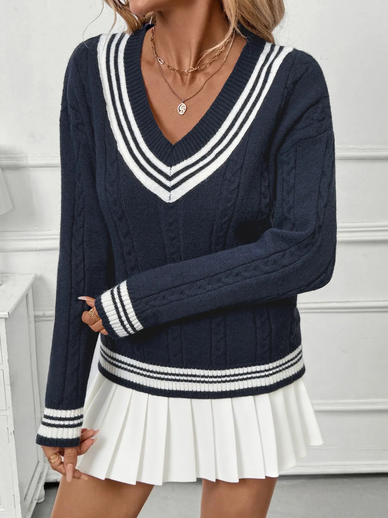 Dark blue V-neck sweater with cable knit texture and contrast stripe trim