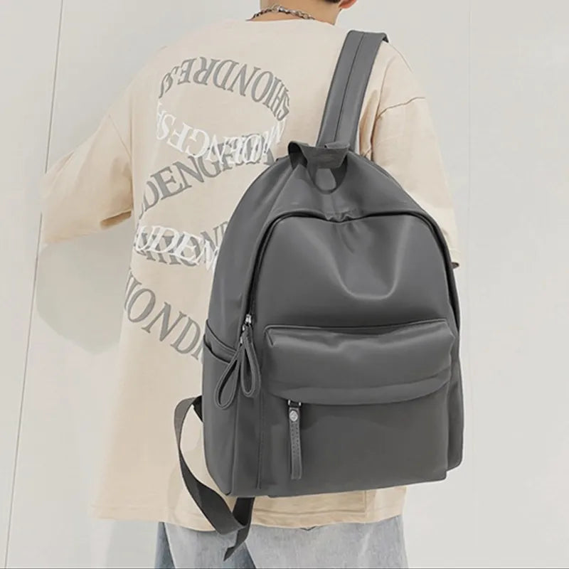 Dark gray vegan leather zip backpack with zip front compartment and cord drawstring