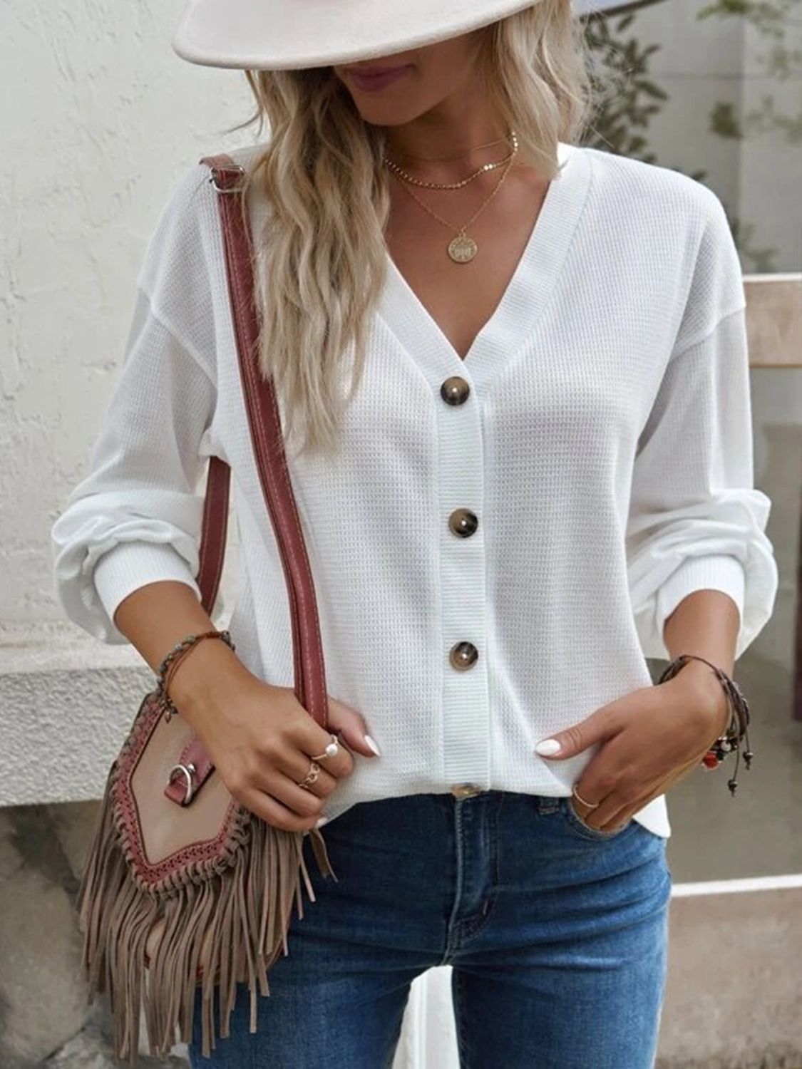 White V-neck blouse with gold-tone buttons and dropped-shoulder long sleeves