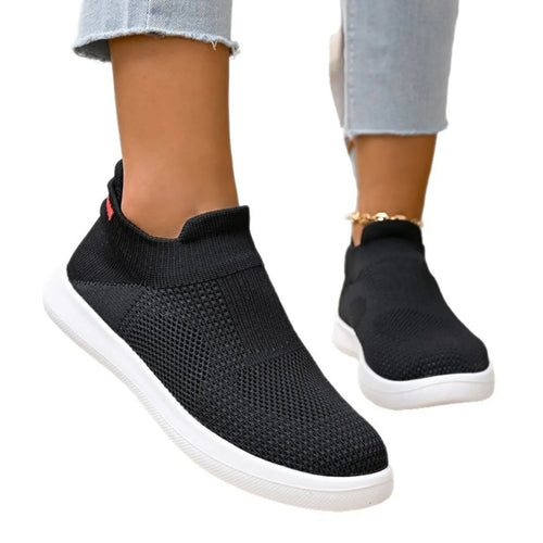 Black mesh sock-style sneakers with white outsole and red side accent