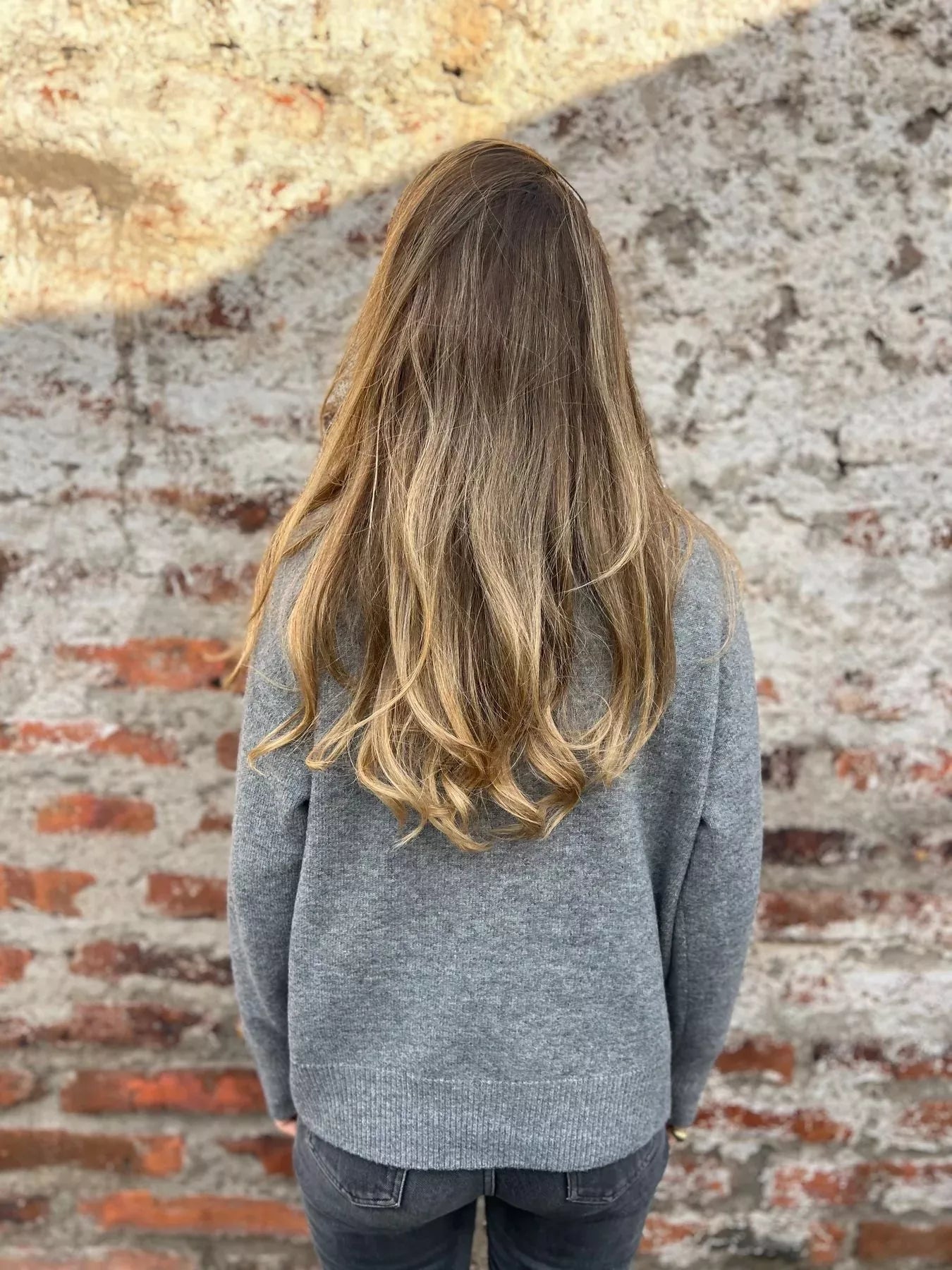 Grey knit turtleneck sweater shown from back, long sleeves