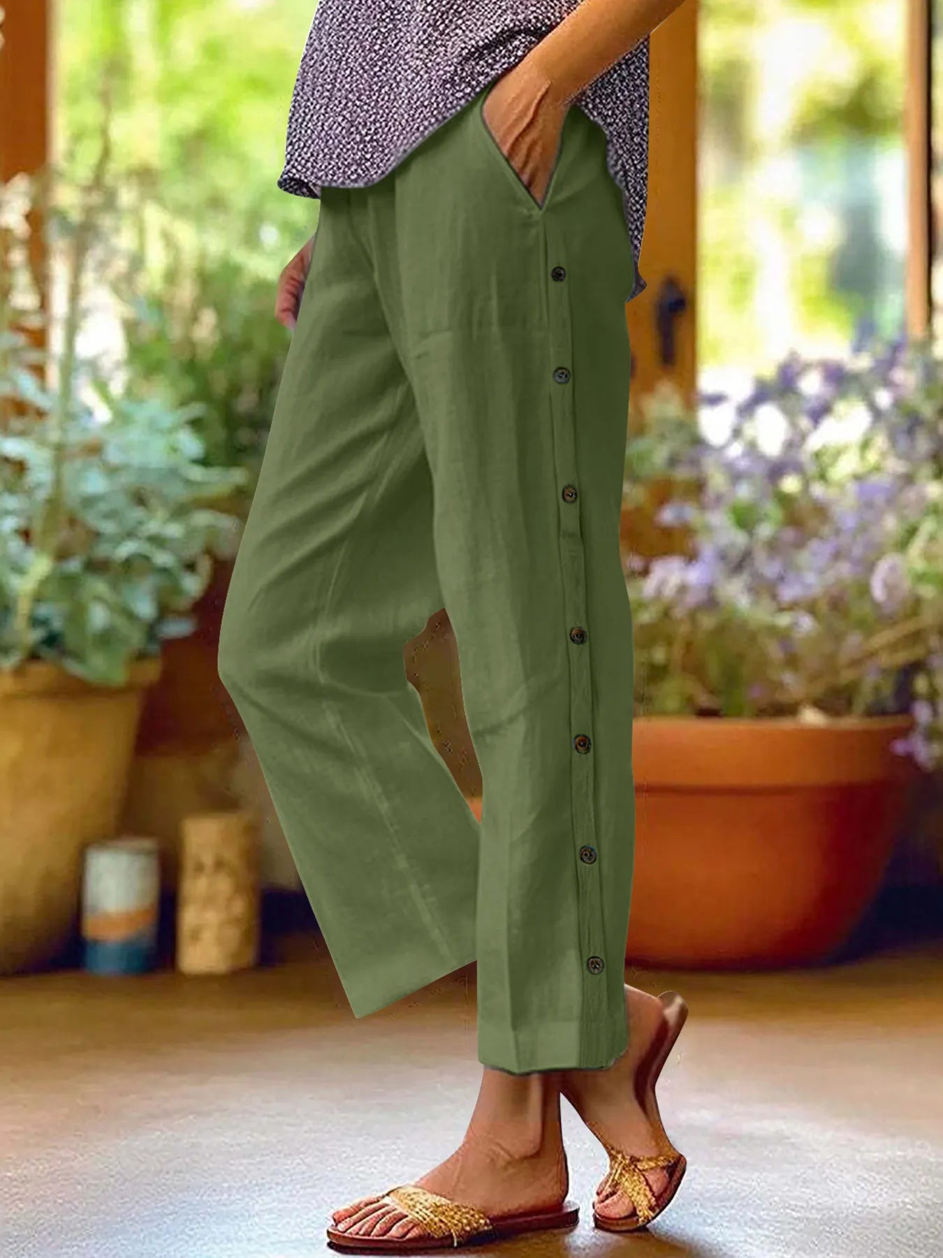 Green wide-leg pants with side button details, styled with casual flats