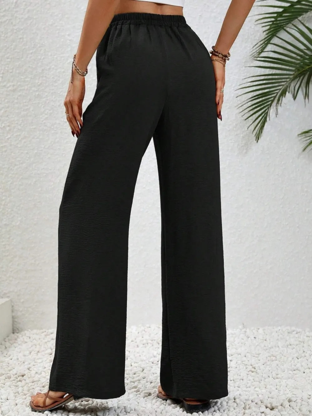 Black wide-leg drawstring pants with elastic waist and full-length flares