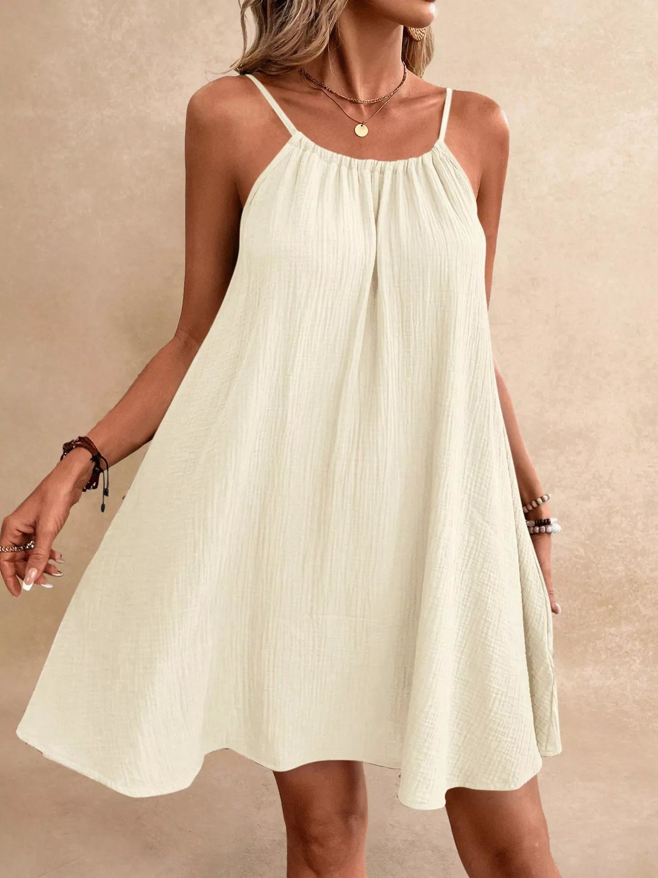 Ivory gauze spaghetti-strap dress with gathered bodice and flared skirt