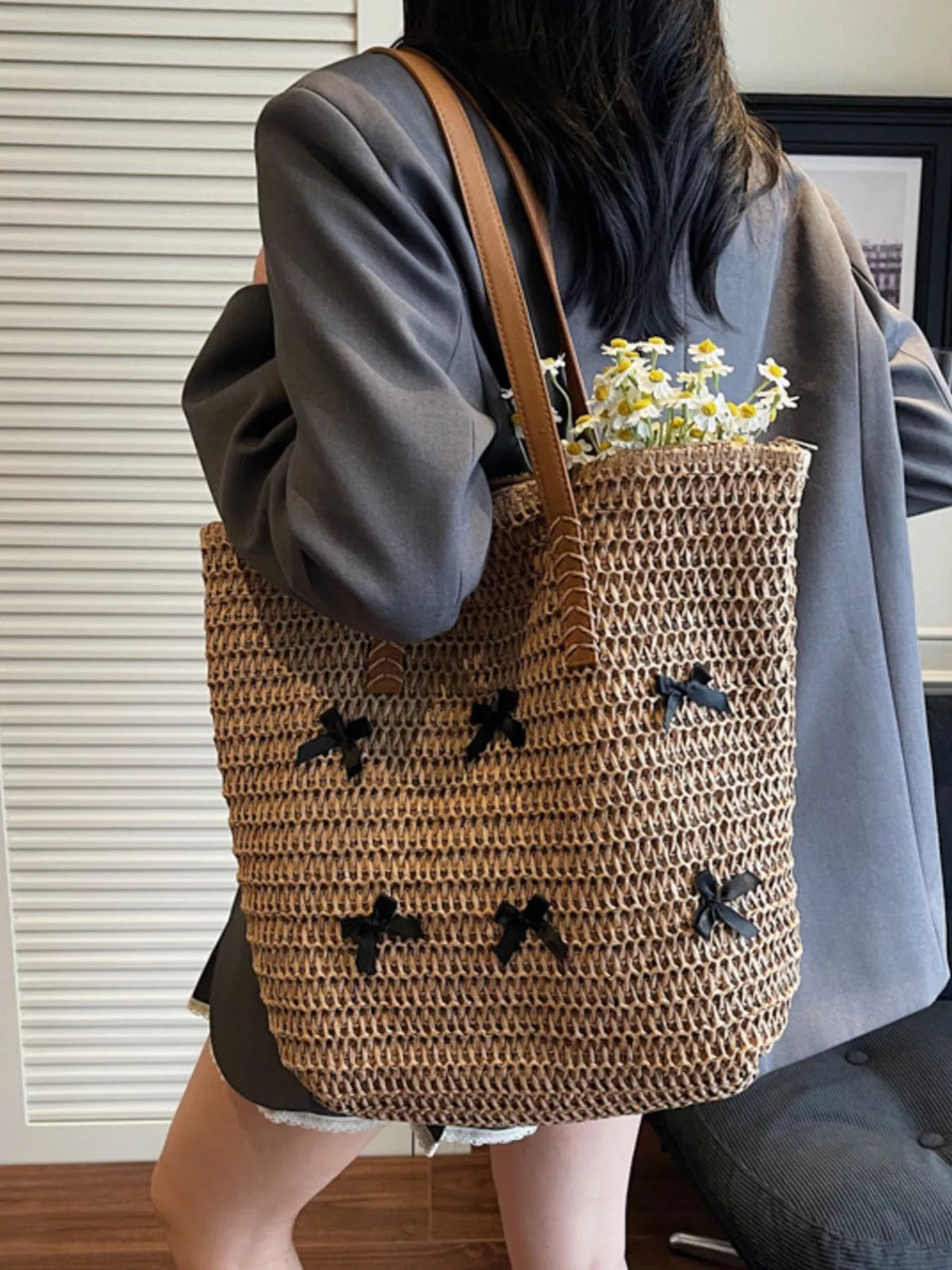Caramel woven straw tote bag with bow applique pattern and leather-look handles
