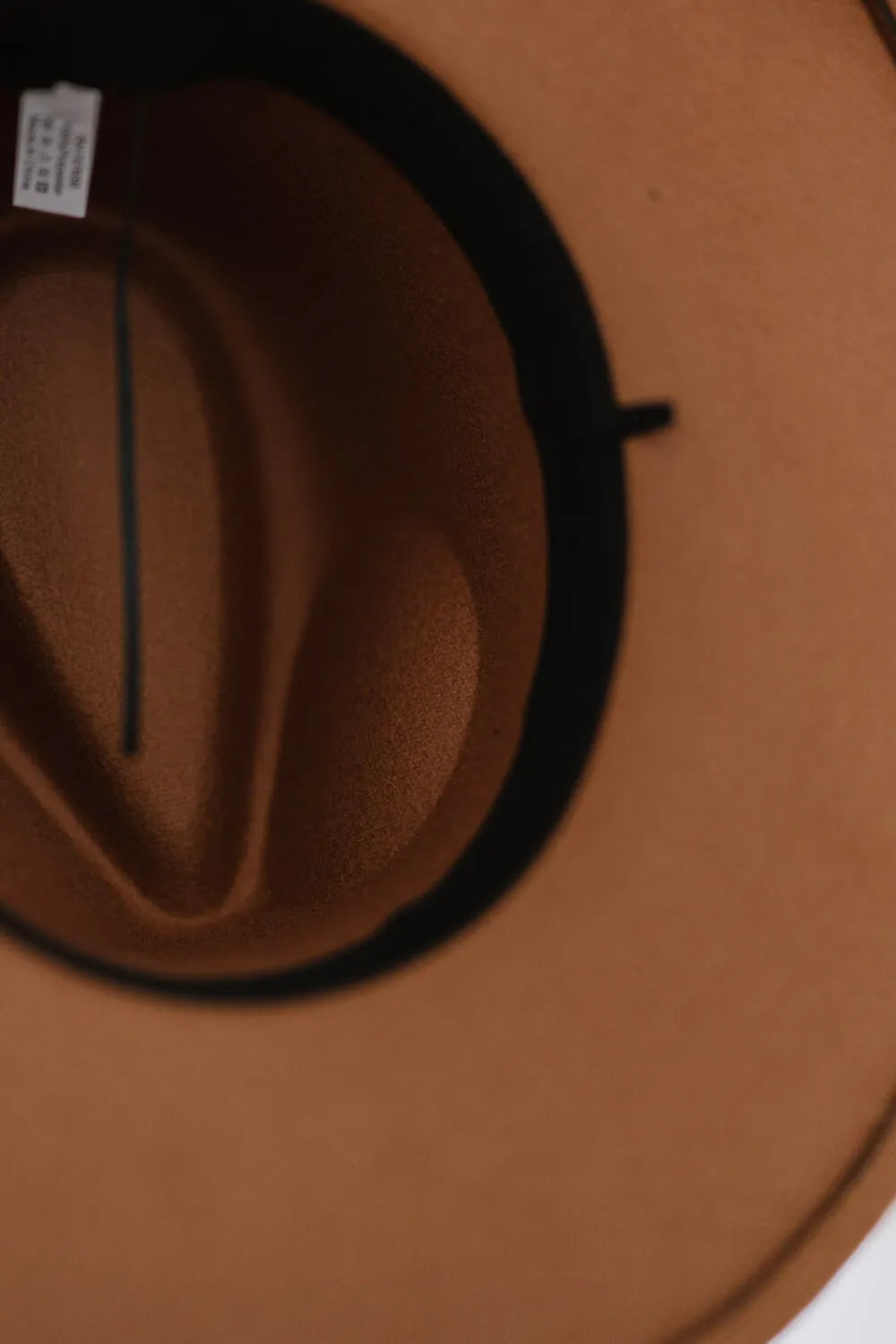 Khaki fedora hat interior with black band and size label