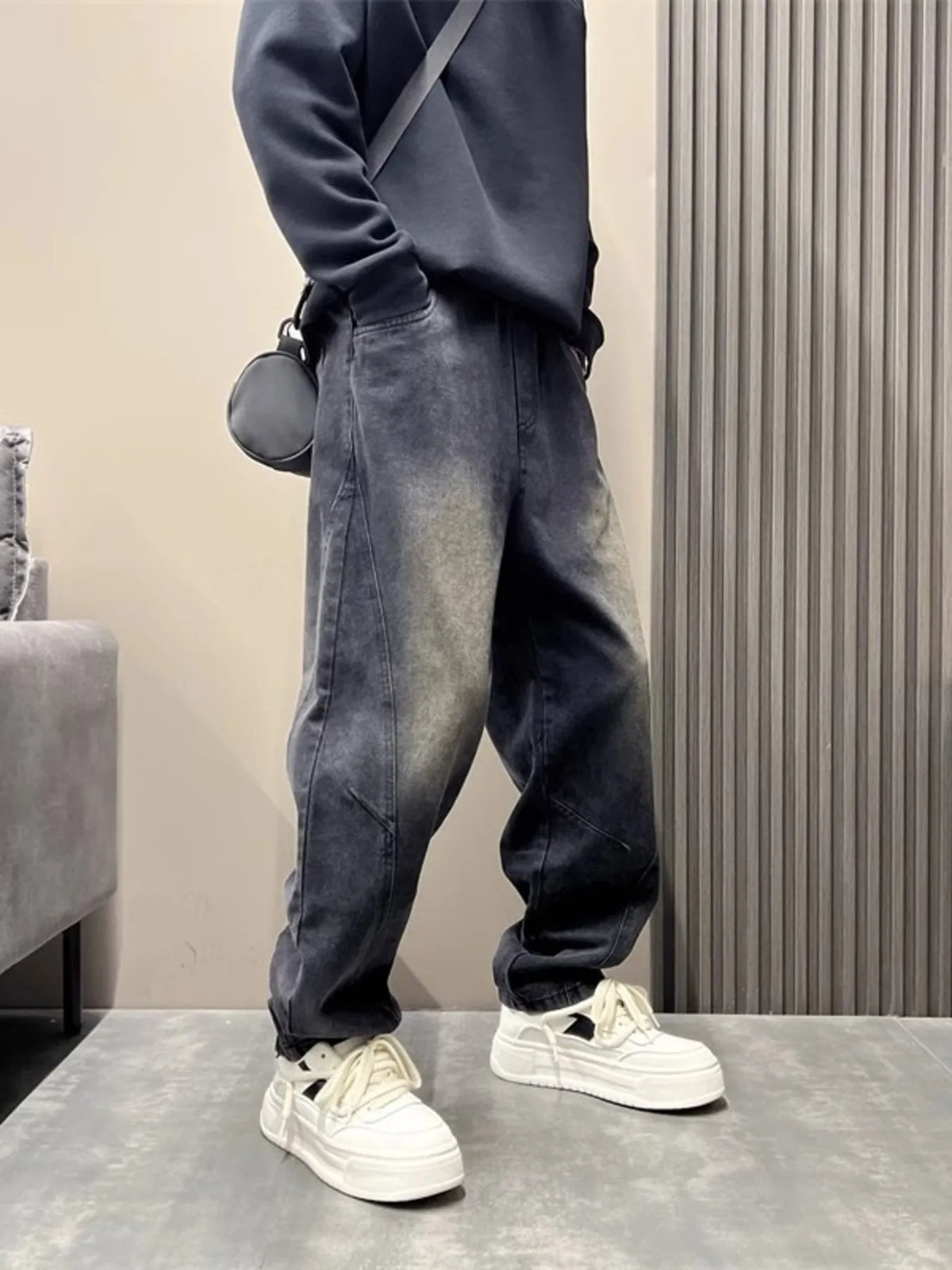Washed black loose-fit stretch jeans with contrast wash, open pockets, and cuffed hem