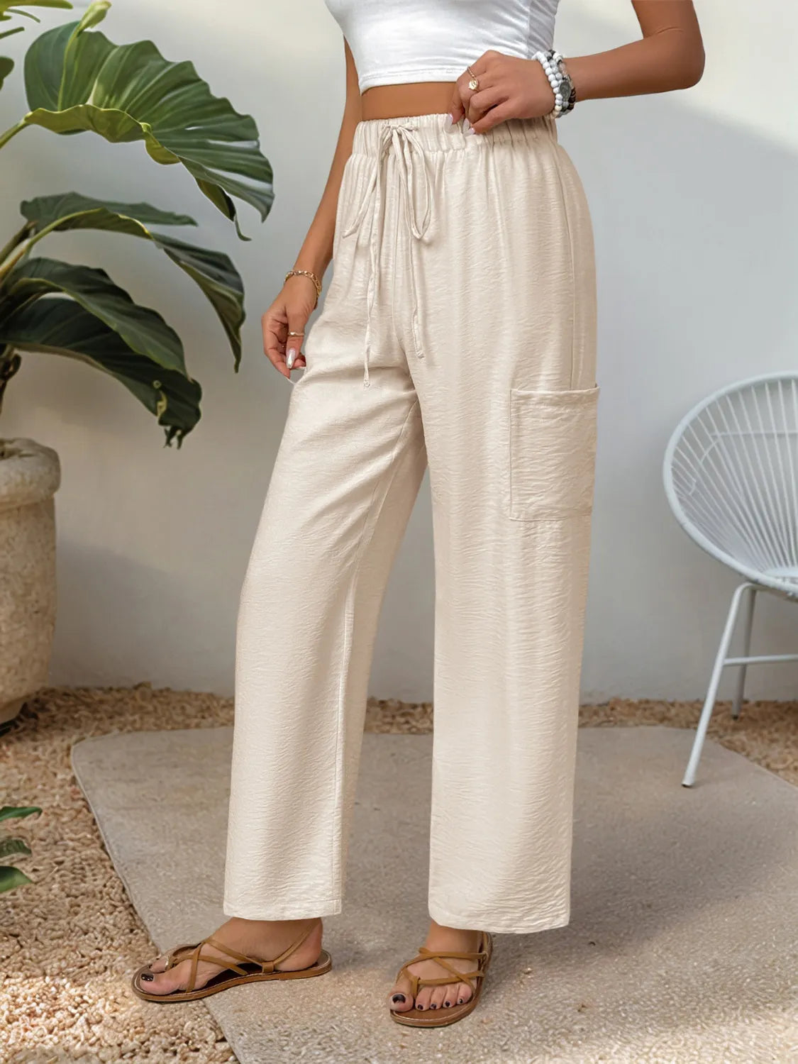 Cream drawstring wide-leg pants with gathered elastic waistband and loose leg opening