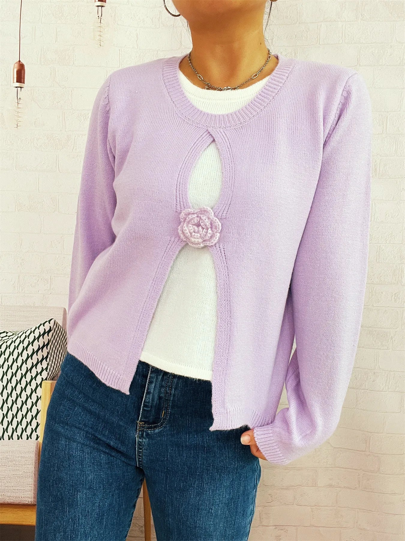 Purple round-neck sweater with white keyhole cutout and center flower appliqué