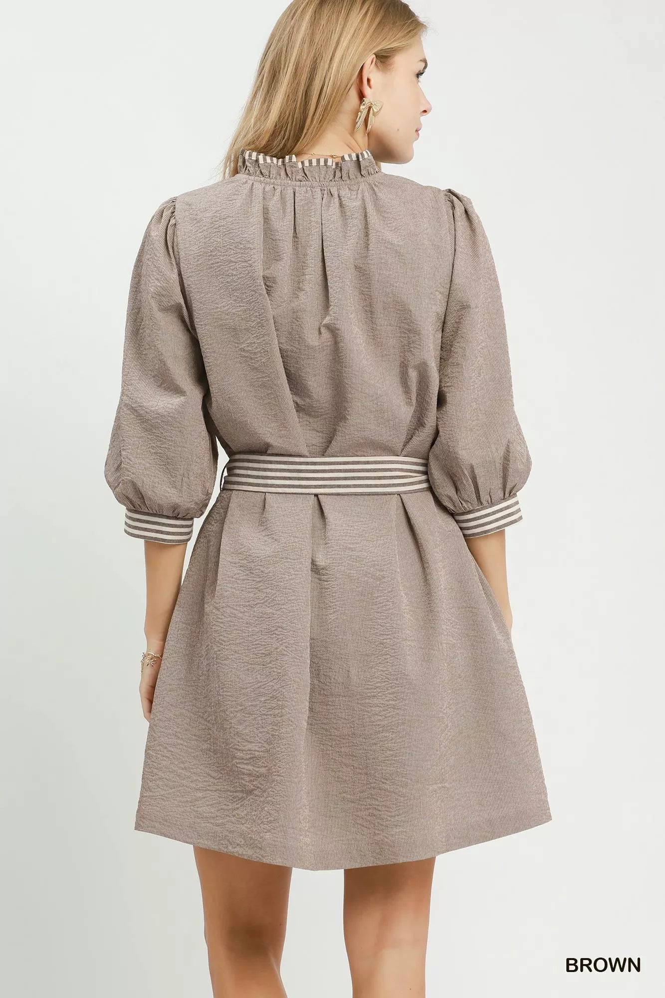 Brown textured mini dress back view with gathered yoke and tie waist belt, striped trim