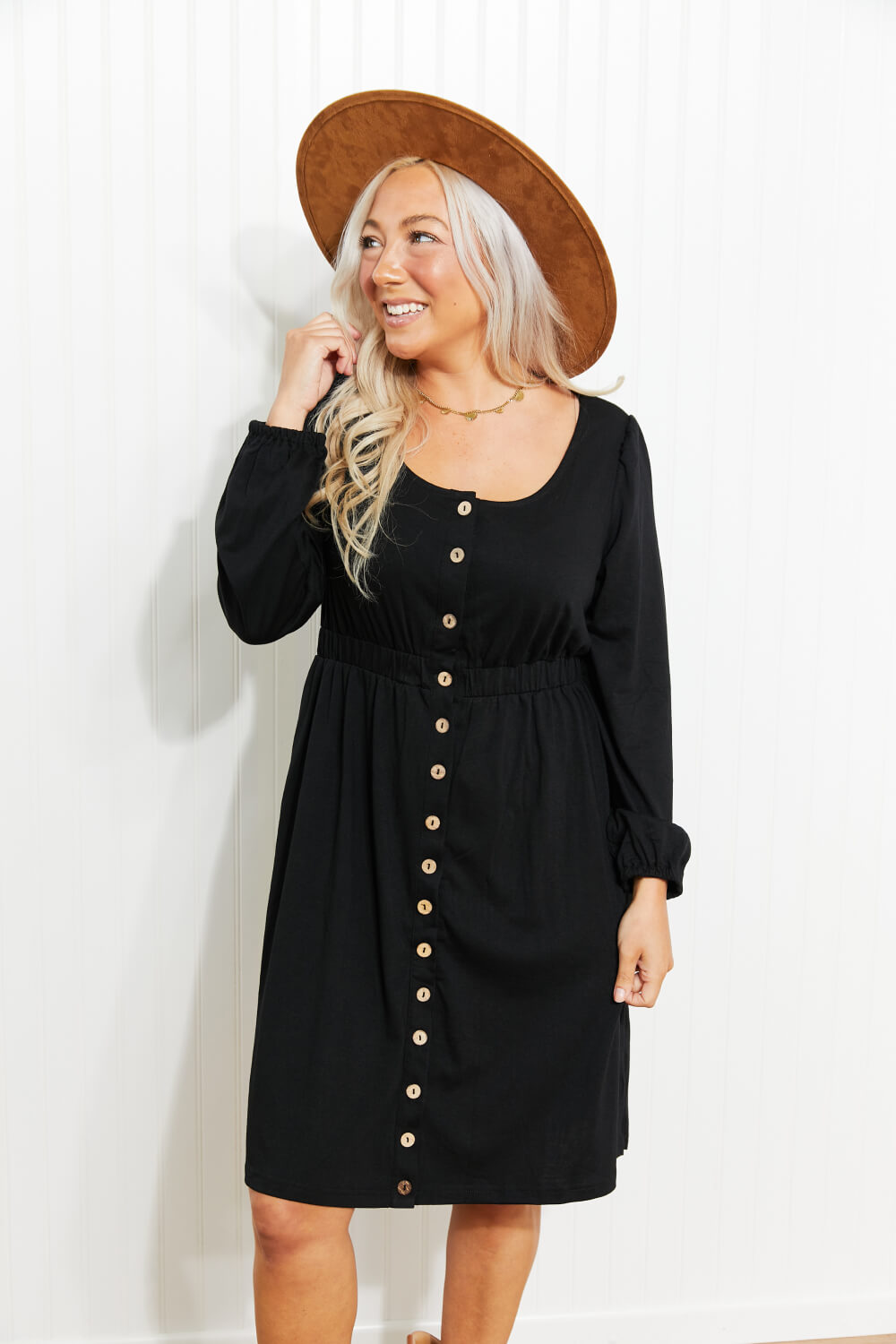 Black long sleeve mini dress with scoop neck, button front, and gathered empire waist